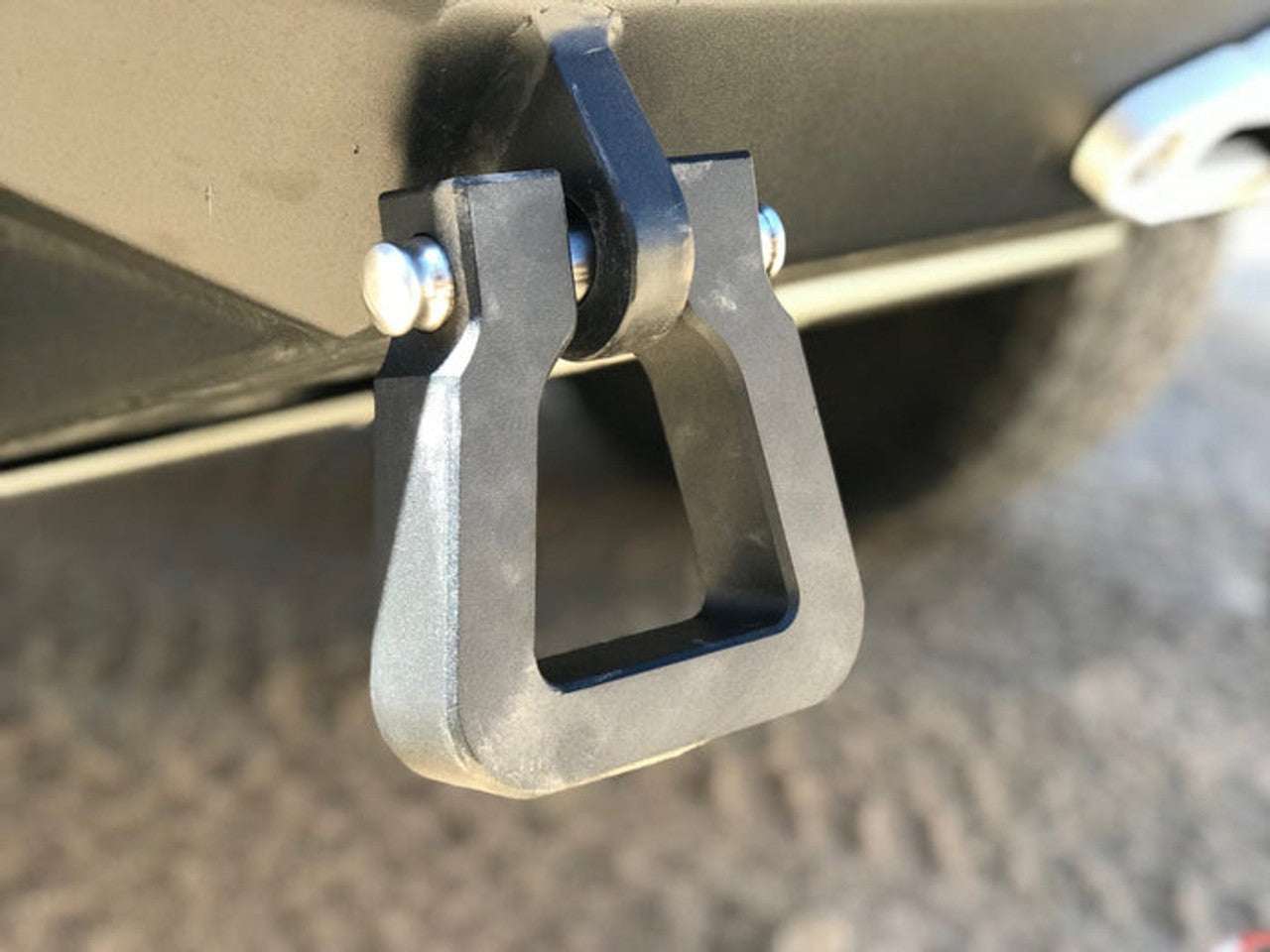 MEGA D-RING BLACK (SINGLE) on vehicle bumper, durable 6061-T6 billet aluminum, 18,000-pound capacity, reversible design.