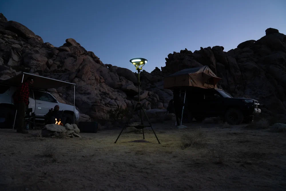 TUFF STUFF® Overland Halo 9.75" solar freestanding light with speaker illuminating a campsite at dusk.
