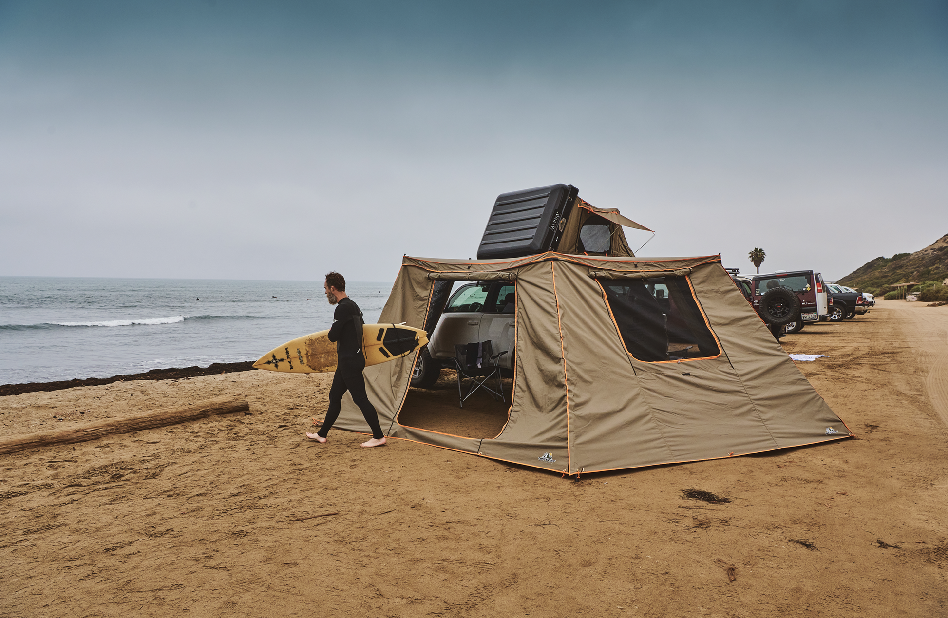 TUFF STUFF® Overland 270 Degree Awning with Shade Wall Pack on a beach, showcasing door and window panels, ideal for camping.