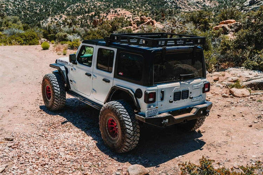 2018-2024 Jeep Wrangler JL with full-width rear bumper in rugged terrain.