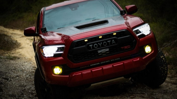 Red  Toyota Tacoma flexing on uneven terrain