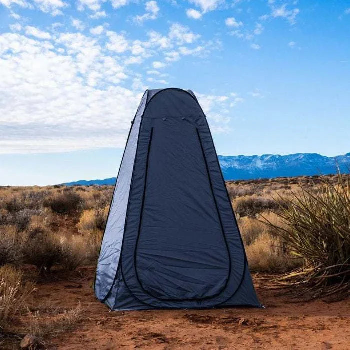 Portable outdoor changing or toilet tent in a scenic desert setting, providing privacy and convenience for camping and travel.