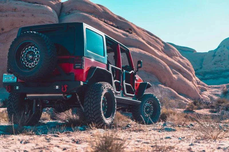 2007-2018 Jeep Wrangler JK equipped with full-width rear bumper, off-road in desert terrain.