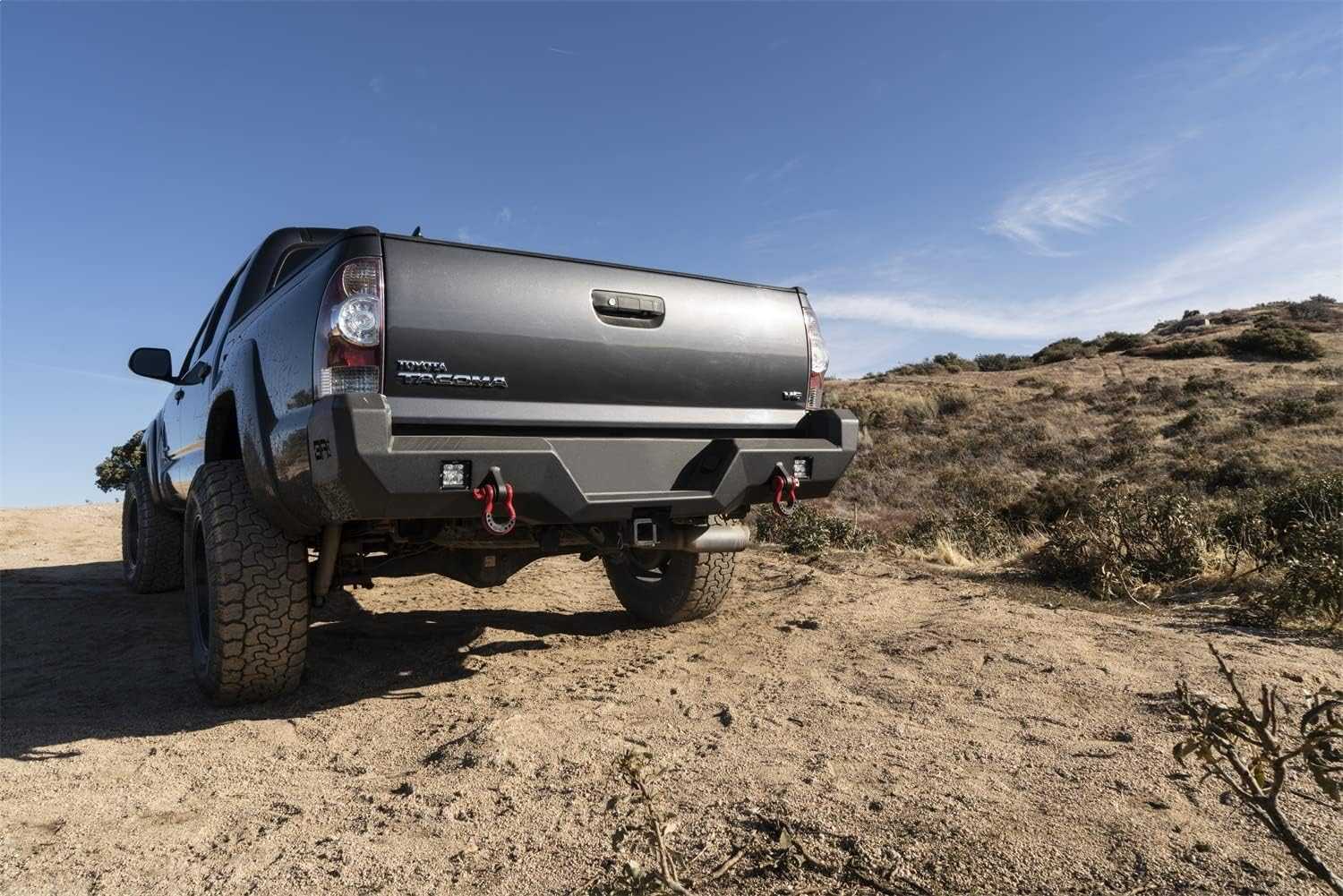 2005-2015 Toyota Tacoma Pro Series Rear Bumper on off-road terrain, showcasing rugged design and functionality.