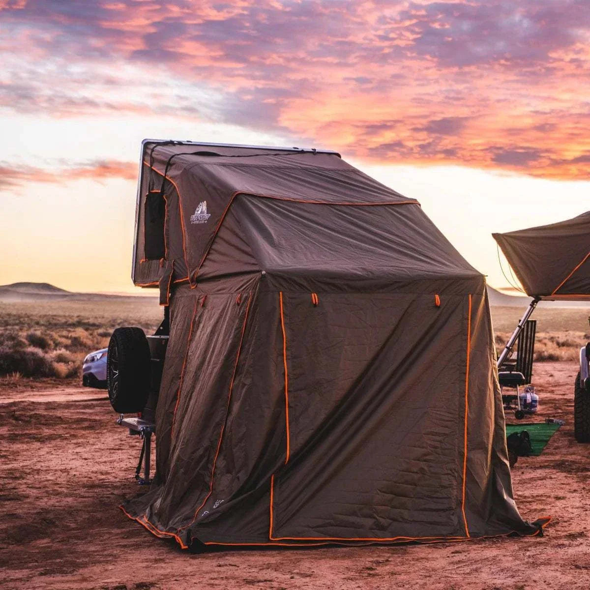 TUFF STUFF® OVERLAND ALPHA™ CLAM SHELL RTT with Annex Room set up in natural landscape at sunset.